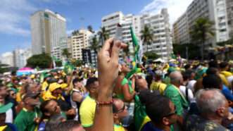 A hand holding a tube of lipstick at a Brazilian protest | Bob Karp/ZUMAPRESS/Newscom
